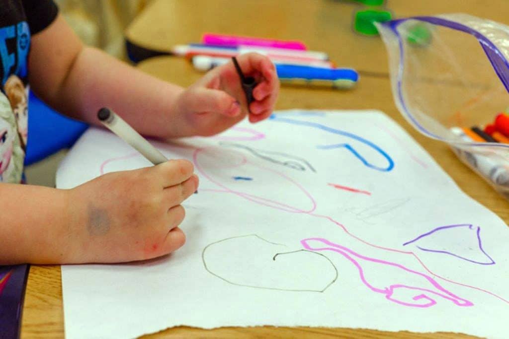 Child drawing with crayons.