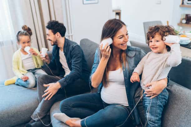 Family having fun playing with string phones at home