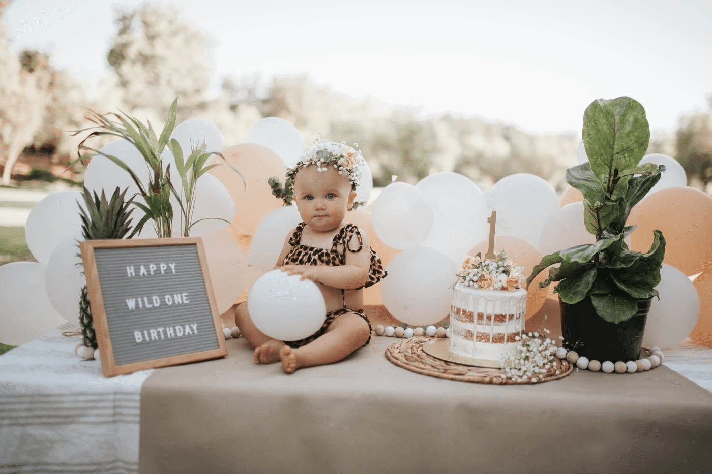 A baby girl's jungle birthday party with a cake and numbers