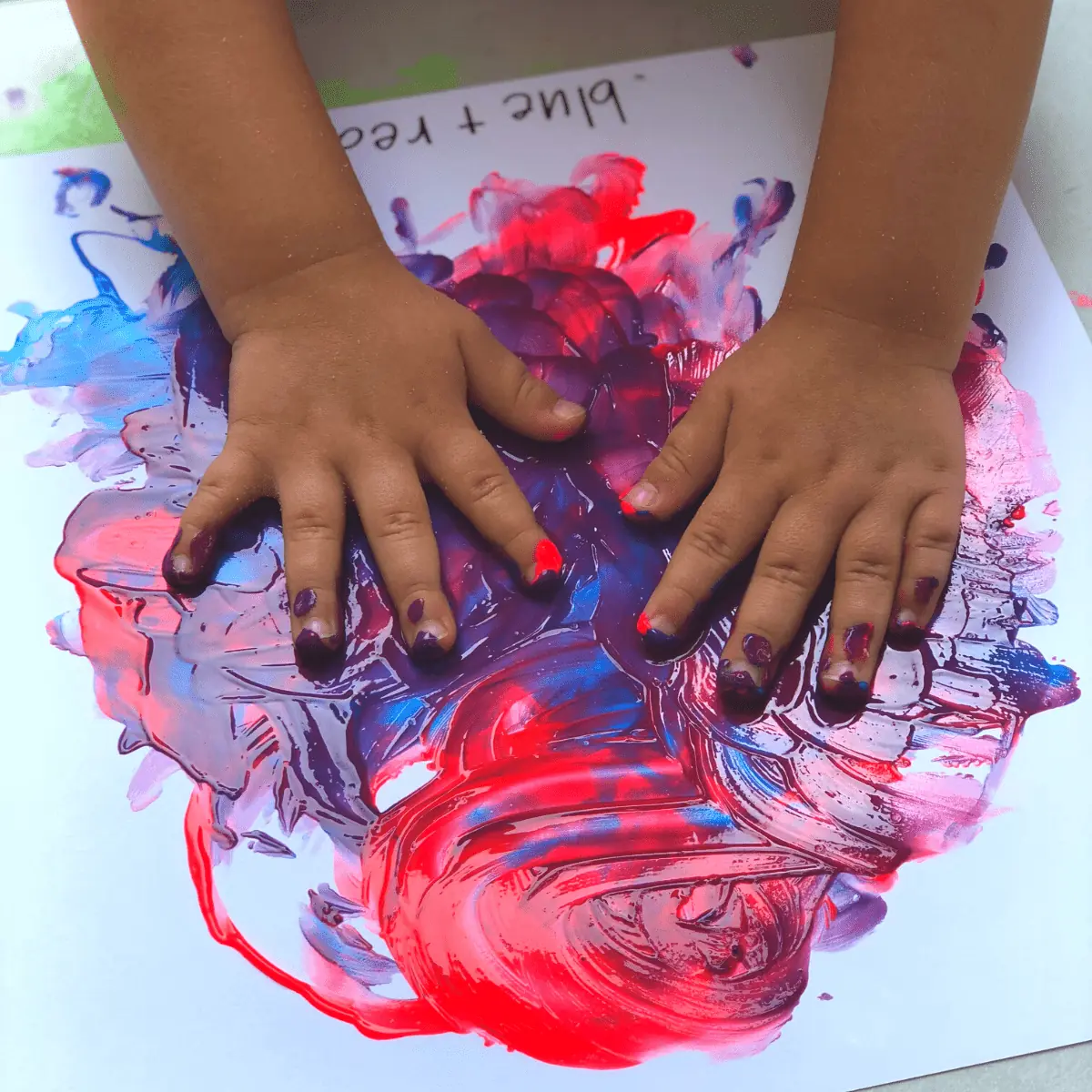 A child's hands, adorned with red, blue, and white paint, showcasing creativity in a playful manner