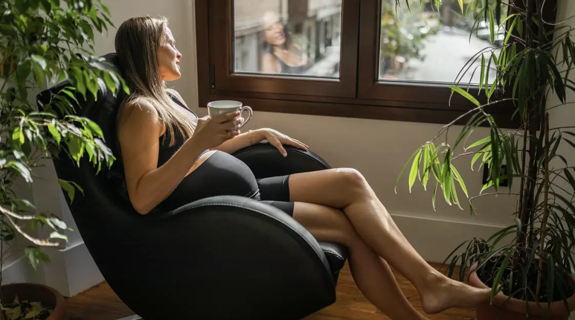 A pregnant woman cherishing a calm moment in a chair, savoring a cup of coffee, prioritizing emotional wellness during pregnancy