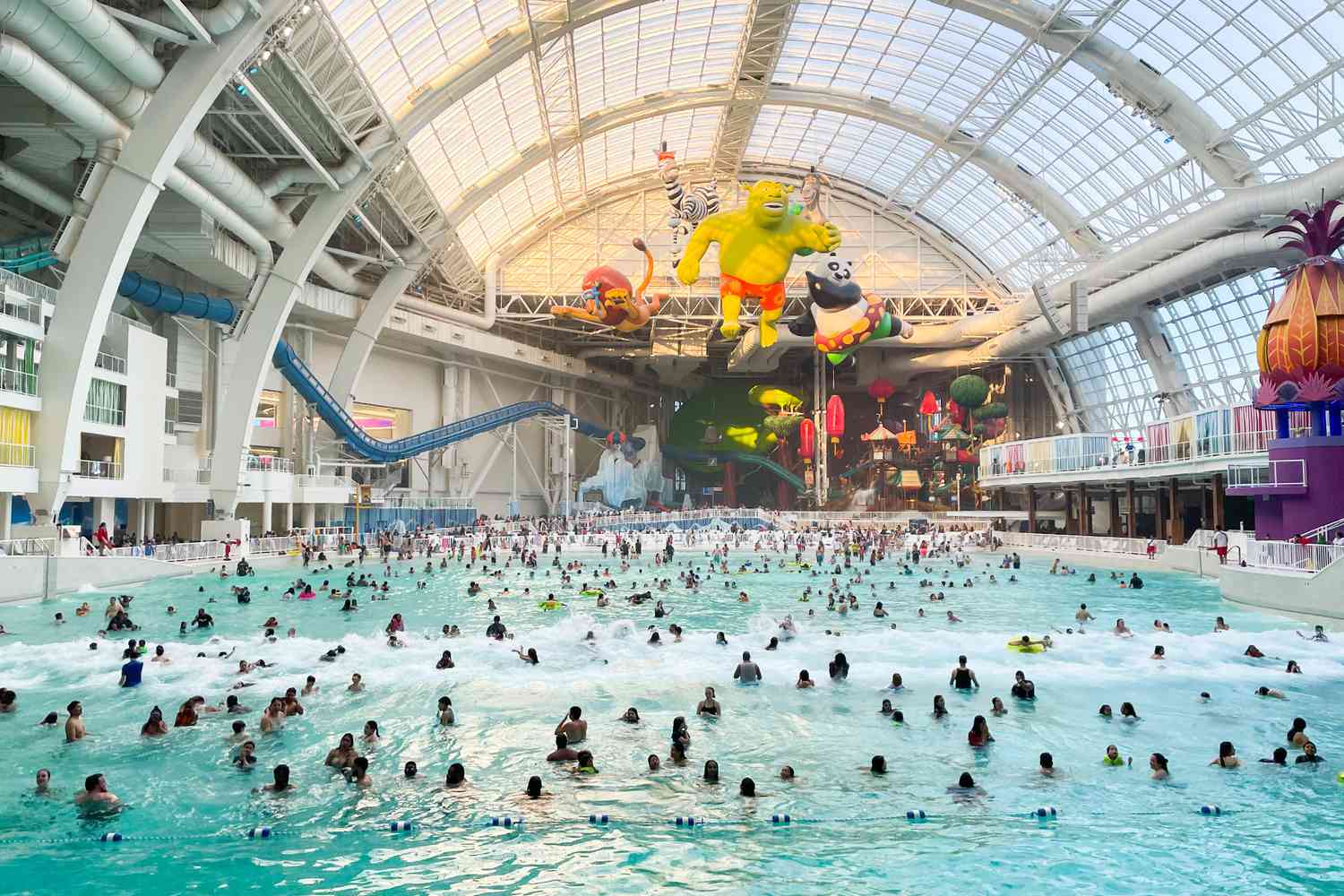 People enjoying a refreshing swim in a spacious indoor water park. Dive into fun and relaxation with more stay time