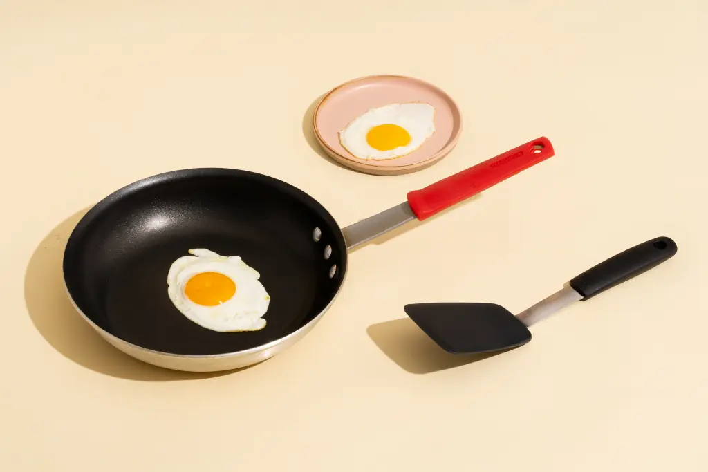 A cooking egg in a non-stick pan with a spatula