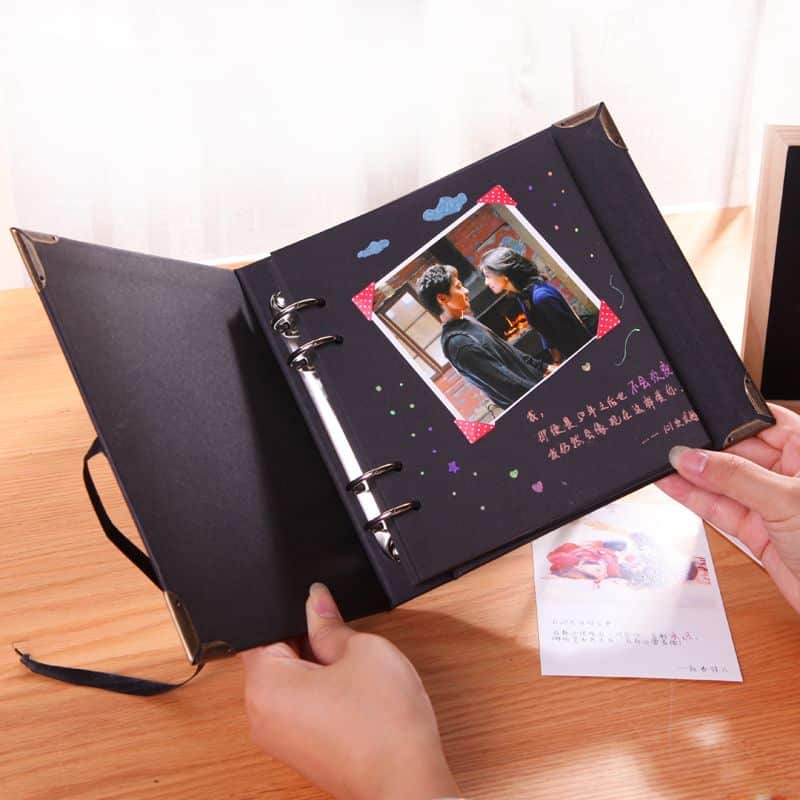 A person holding a personalized photo album with a cherished picture inside.
