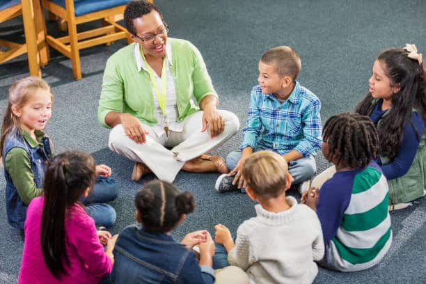 A teacher engaging with children in a circle