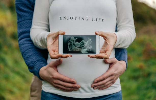 Pregnant couple joyfully displaying a snapshot of their unborn child