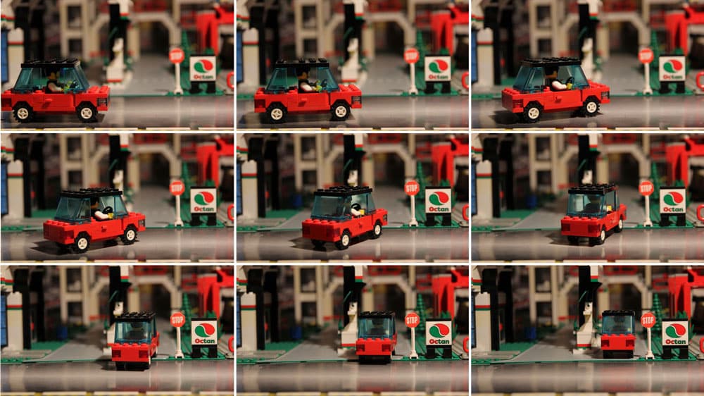 Stop motion film of a red car driving through a city