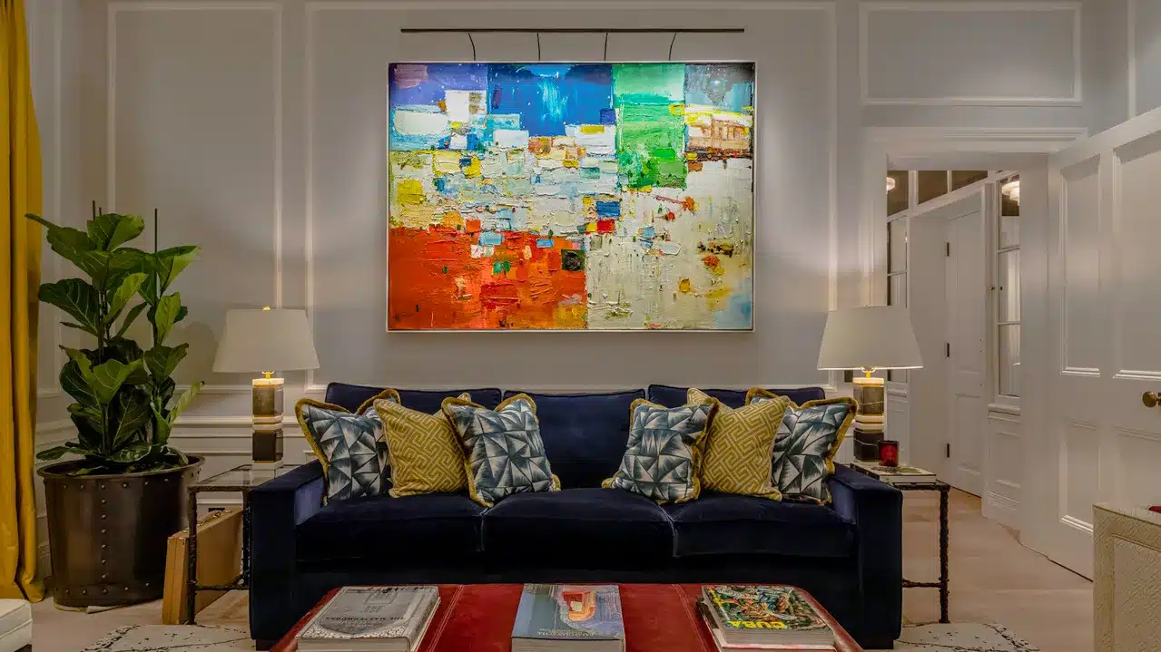 Colorful painting enhances living room decor, adding vibrancy. Thoughtful lighting and positioning create an inviting space