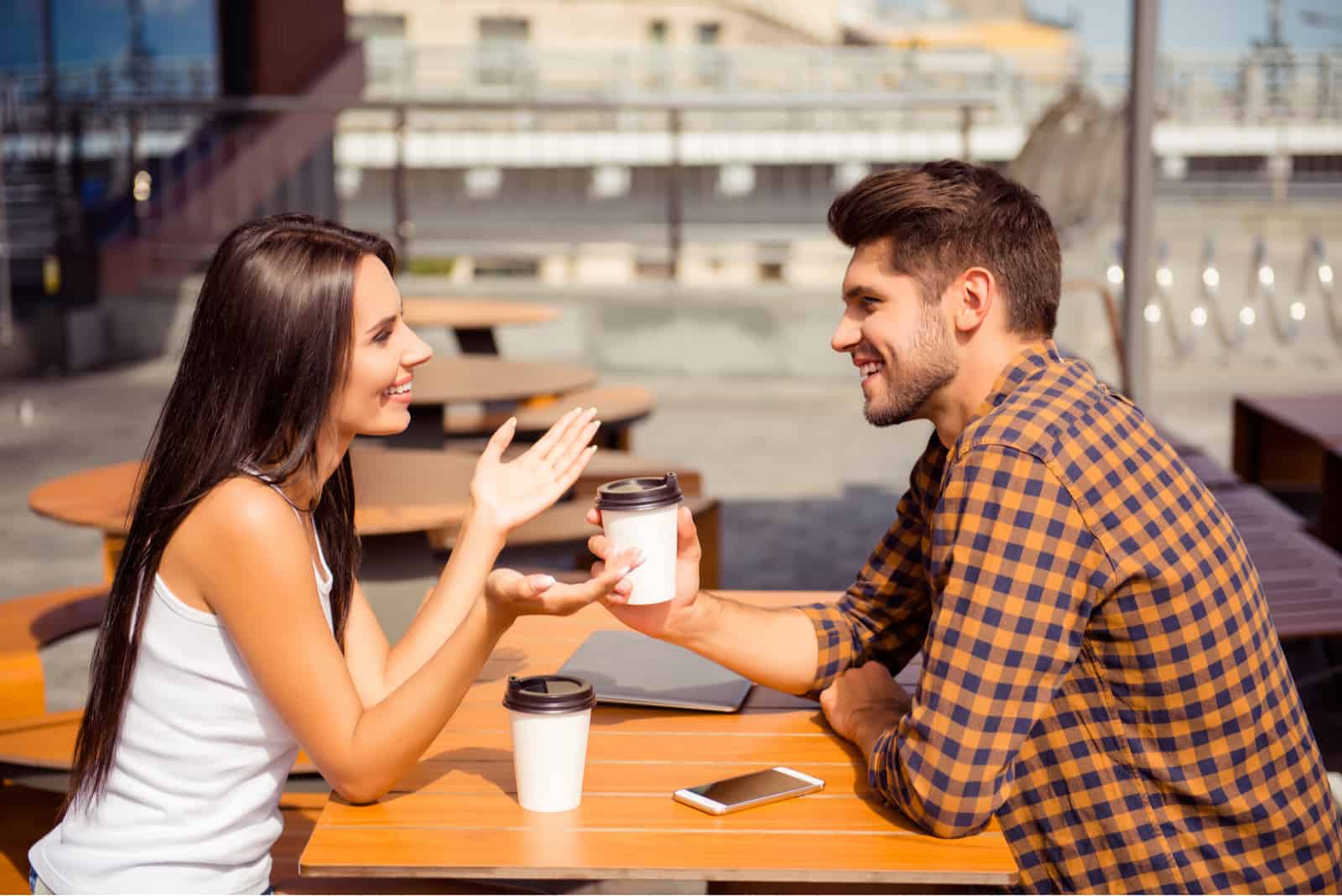 A couple engaged in conversation at a cafe, discussing topics with a backdrop of cozy ambiance
