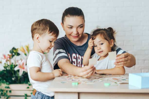 Mother playing with her children at home in cards, Leisure activity at home